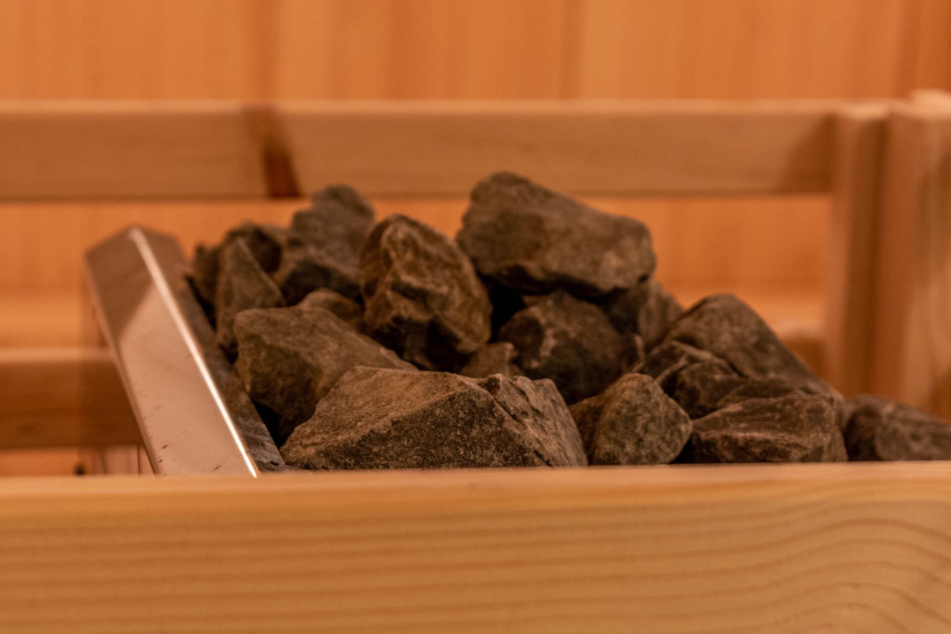 Una caja de madera llena de piedras oscuras.