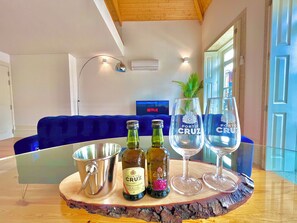 A room with a blue sofa, a glass table with a bottle and glasses, and a TV displaying Netflix. - Porto Domus 210 Penthouse (Porto)