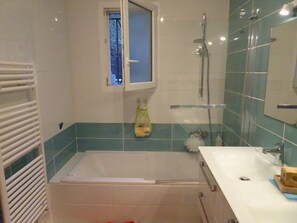 Bañera con ducha, secador de pelo, papel higiénico