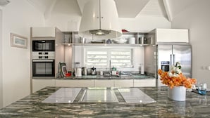 Una cocina moderna con una isla central, electrodomésticos integrados y un amplio ventanal.