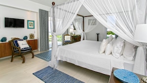 Un dormitorio con cama con dosel, televisor y vistas al exterior.