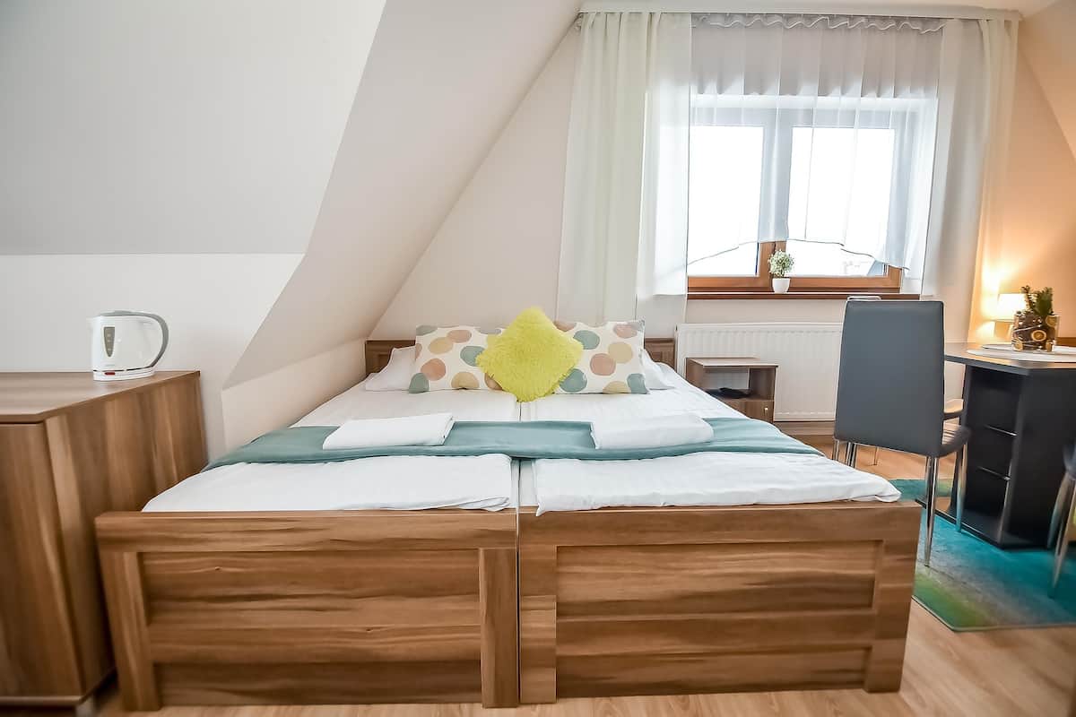 A modern bedroom with a wooden bed, a desk, and a chair.