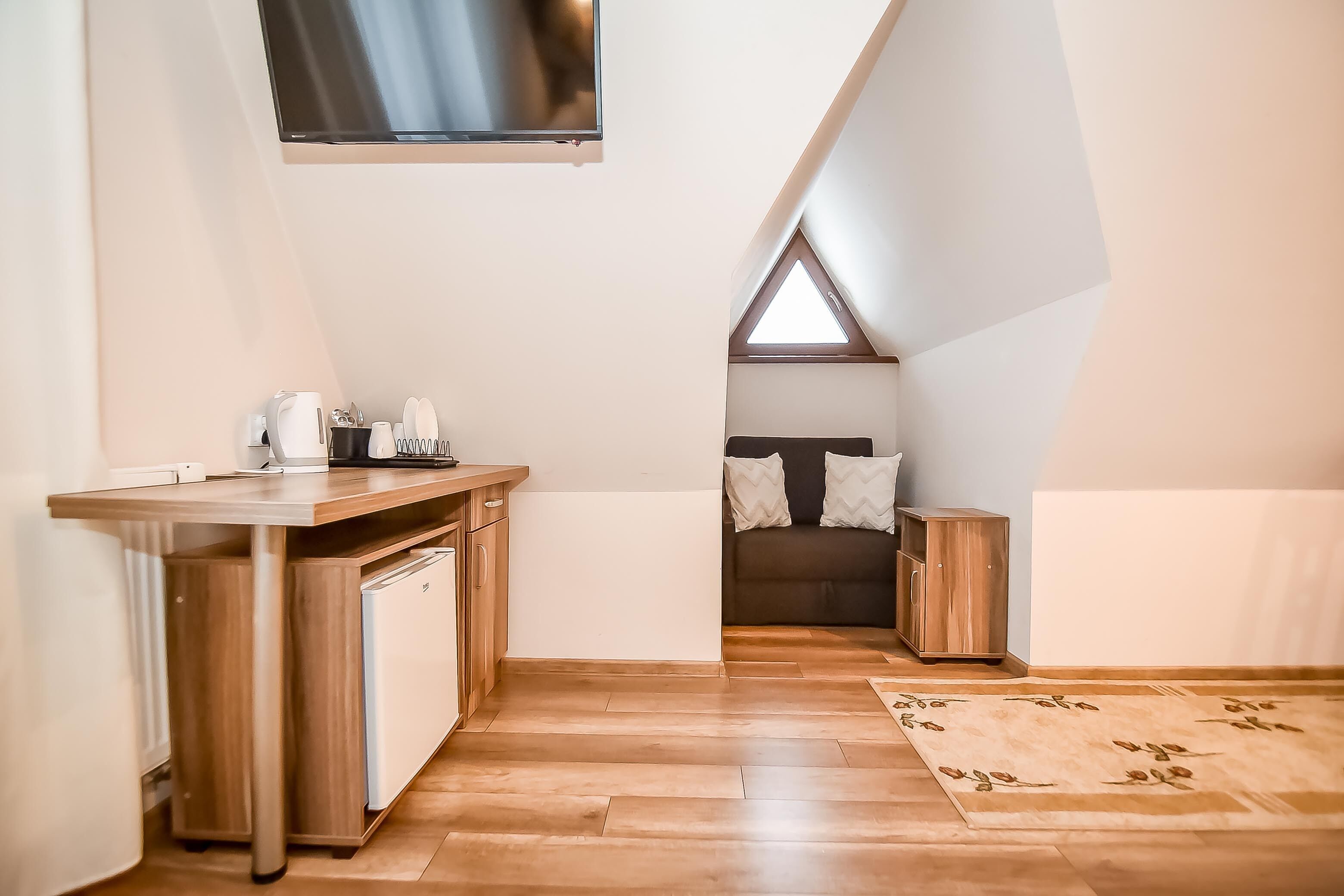 Une pièce compacte et moderne, dotée d’une kitchenette, d’un lit et d’une lucarne.