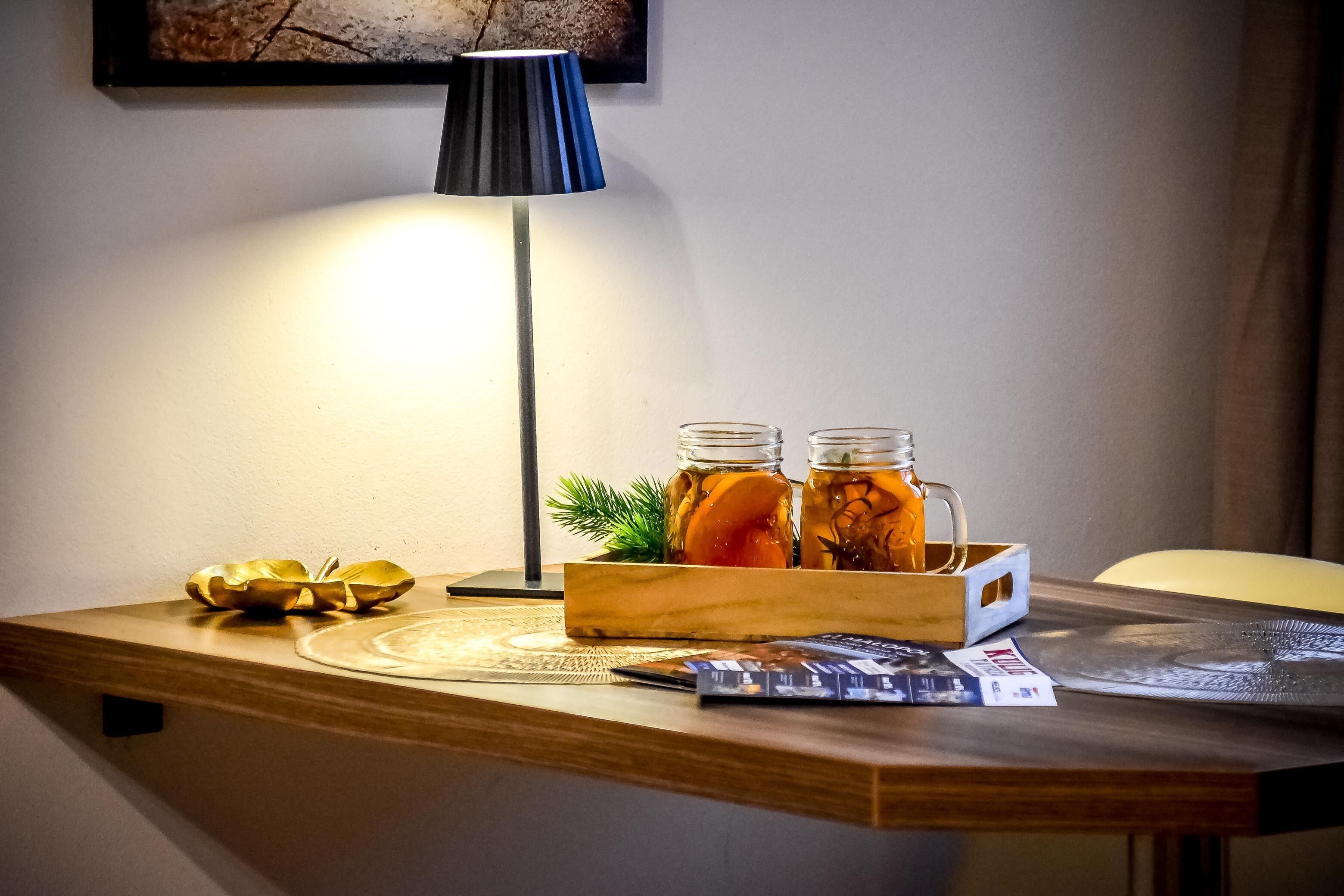 A wooden table with a lamp, a tray with jars, a decorative bowl, and a magazine.
