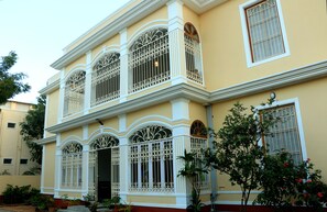 A two-story building with ornate white window railings and a balcony. - La Taara (Vanur)