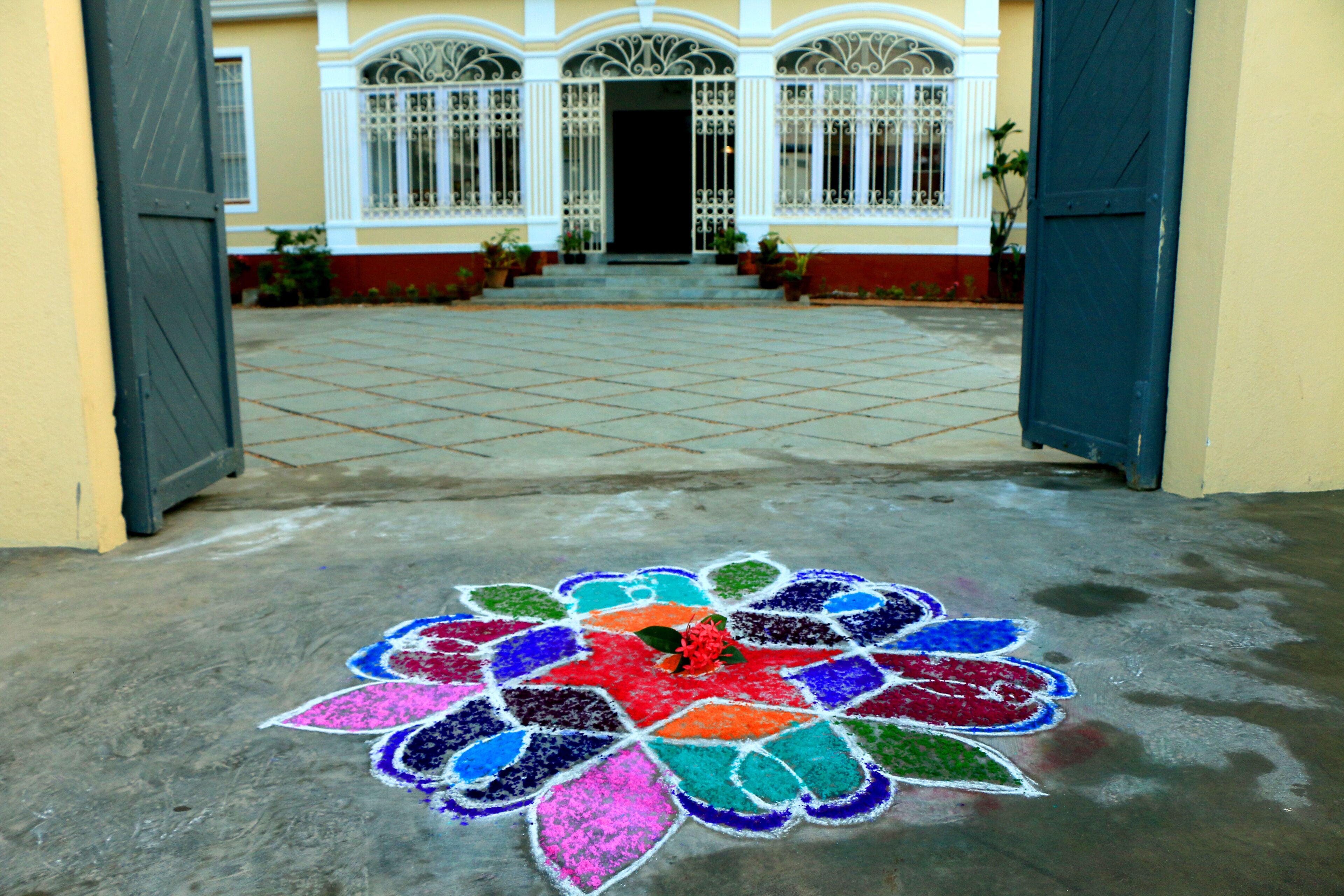 A courtyard with a colorful rangoli design on the ground.