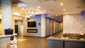 Eine Lobby mit einer Rezeption, einem Flachbildfernseher, einem Kamin und einer Sitzecke.