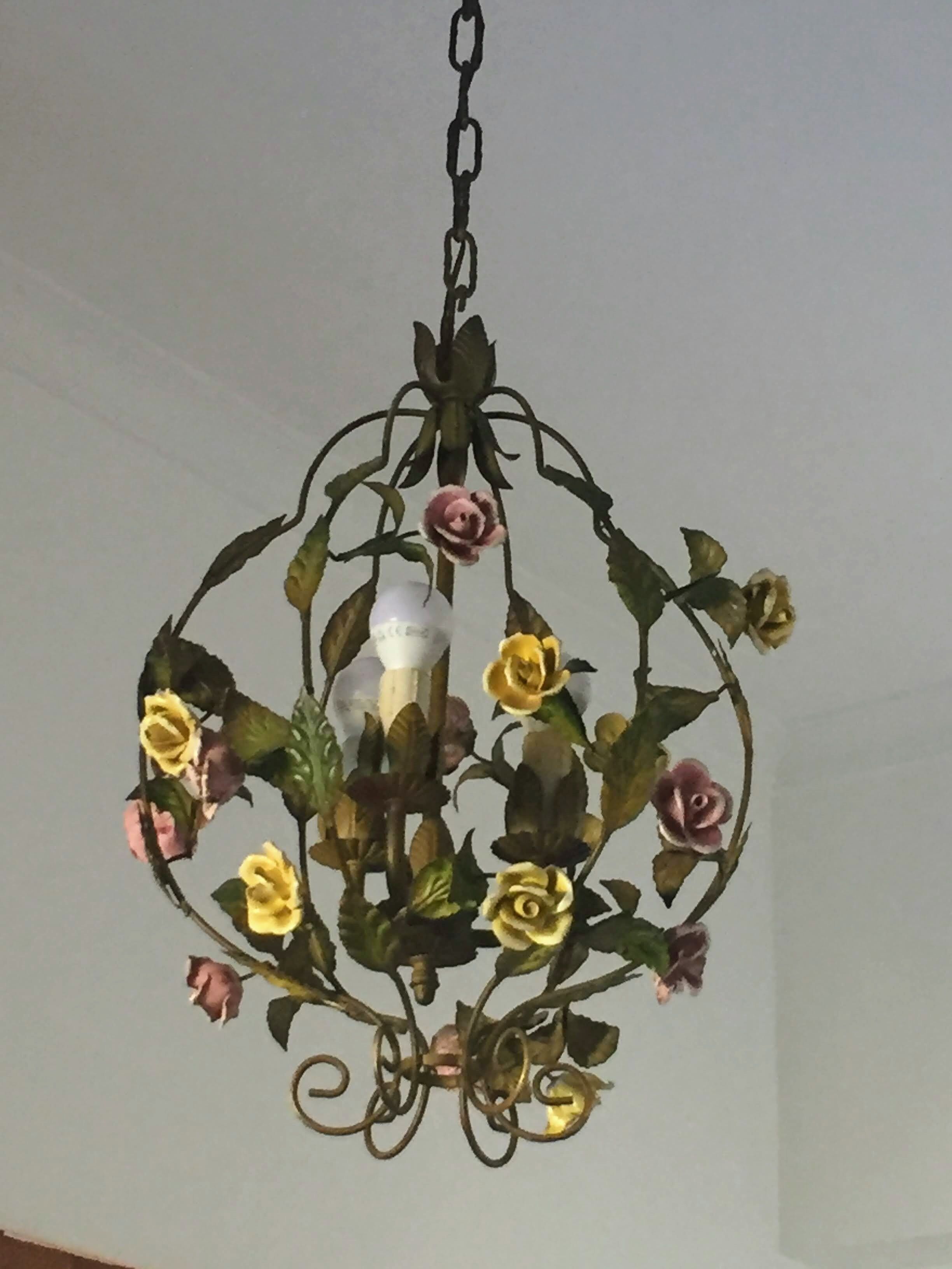 Un candelabro con diseño floral que incluye rosas y hojas.