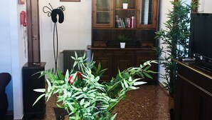 A living room with a wooden cabinet, a television, and a potted plant on a table. - Panoramic and Bright Penthouse is Waiting for you (Rome)