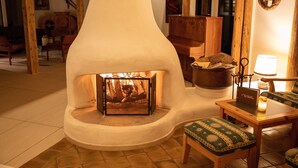 A cozy room with a fireplace, wooden furniture, and a tiled floor. - Alpenlodge Val Gronda (Obersaxen)
