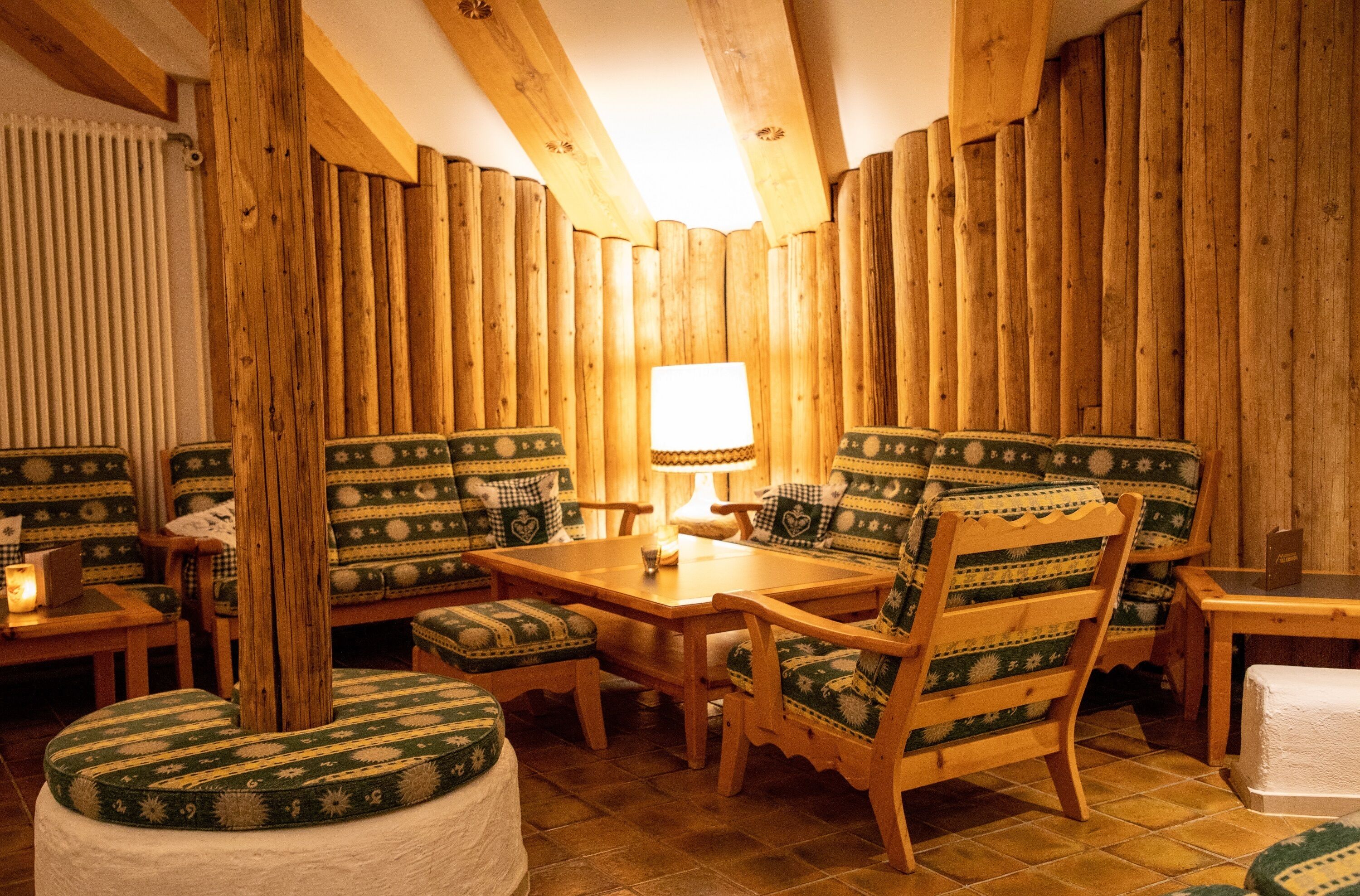 Une pièce chaleureuse avec des murs en bois, une table en bois et des chaises assorties.