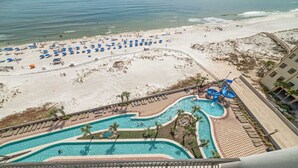 A resort with a large pool area, a beach with umbrellas, and a water slide. - New to the Rental Market, New Owner, Beachfront!! (Orange Beach)