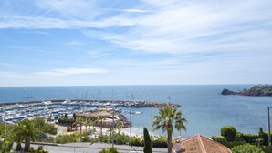 A marina with boats docked, a rocky outcrop, and a clear blue sky. - Villa La Cigalette-Gaia's Villas,Beachside Estate with Pool-Steps from the Beach (Théoule-sur-Mer)
