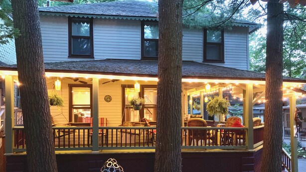A two-story building with a covered porch, outdoor seating, and potted plants. - Beautiful Yr Round Cottage Great Porch, Heart of MTG, Near Hershey, Lititz, Lanc (Mount Gretna)