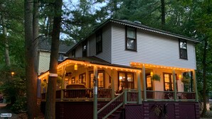 A two-story house with a porch, stairs, and string lights. - Beautiful Yr Round Cottage Great Porch, Heart of MTG, Near Hershey, Lititz, Lanc (Mount Gretna)