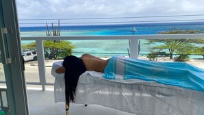 A room with a view of a beach and ocean.