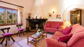 A cozy living room with a fireplace, a pink sofa, and a coffee table. - MORENO. Fabulous garden, memorable holidays (Pollensa)