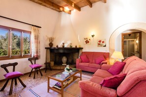 A cozy living room with a fireplace, a pink sofa, and a coffee table.