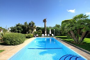 A swimming pool with a clear blue water surface, surrounded by palm trees and greenery. - MORENO. Fabulous garden, memorable holidays (Pollensa)