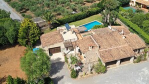 Il s’agit d’une propriété résidentielle dotée d’une piscine, de plusieurs bâtiments et entourée de verdure.