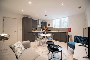 Una cocina moderna con comedor, sofá y televisor.