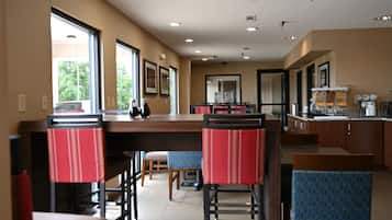 A spacious restaurant with high ceilings, large windows, and a bar area.