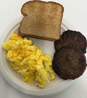 Un plato con huevos revueltos, dos hamburguesas y una rebanada de tostada.