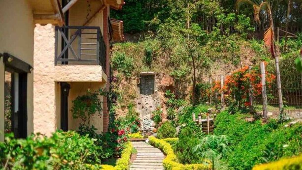 Un chemin menant à un bâtiment doté d’un mur en pierre et d’une clôture en bois.