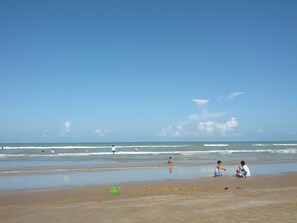 Een strand met mensen die spelen en ontspannen.