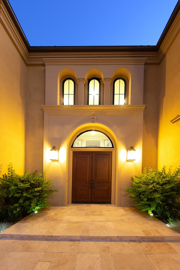 Stately building with a central entrance, arched windows, and a decorative archway.
