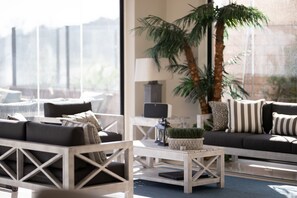 Relax in a serene space with a sofa, armchairs, and a coffee table, offering a comfortable spot to unwind.