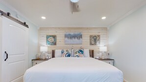 Una camera da letto con un letto grande, una testiera in legno, due comodini con lampade e un'opera d'arte appesa al muro.