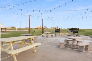 Enjoy dining and socializing in this outdoor space with picnic tables and string lights.
