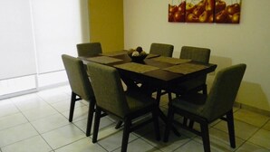 A dining area with a round table, six chairs, and a fruit bowl. - Casa Vacacional en la Playa (Mazatlán)