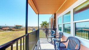 A balcony with a view of the beach and buildings. - Walk to Sandfest, Shared Pools, Boardwalk to Beach (Port Aransas)
