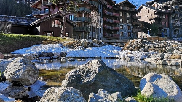 Un rifugio di montagna con numerosi balconi e vista sulle montagne innevate.
