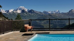 Una piscina con vista sulle montagne innevate.