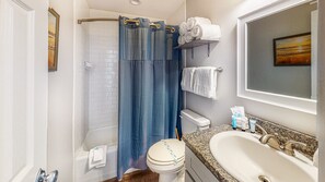A bathroom with a shower, toilet, sink, and towel rack. - Walk to Sandfest , Shared Pool, Board Walk to Beach (Port Aransas)