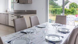 Una cucina moderna con un'ampia finestra, tavolo da pranzo apparecchiato con piatti, bicchieri e posate.