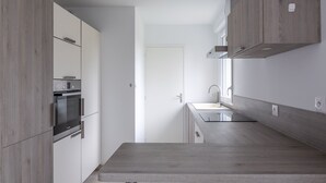 Una cucina moderna con mobili in legno, forno integrato e piano di lavoro.