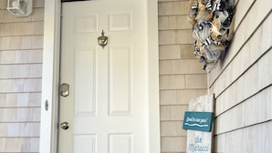 A white door with a mailbox and a sign that reads "The Marucci Beach House". - Let the Sea Set You Free (South Kingstown)