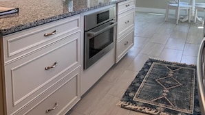 A modern kitchen with granite countertops, stainless steel appliances, and a large island. - Let the Sea Set You Free (South Kingstown)