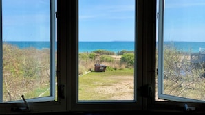 A room with three windows overlooking a beach. - Let the Sea Set You Free (South Kingstown)