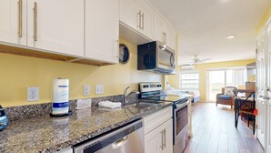 A kitchen with granite countertops, stainless steel appliances, and white cabinetry. - Walk to Sandfest, Shared Pools, Boardwalk to the Beach (Port Aransas)