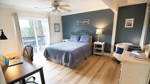 Ein Schlafzimmer mit Bett, Schreibtisch, Stuhl, Nachttisch und Kommode.