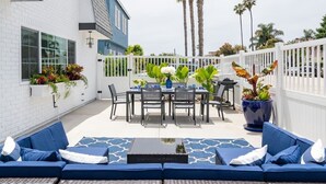 A patio area with a dining table, chairs, and a blue sofa. - FAST WiFi, NEW 1 Block to Beach Sparkling Clean A/C BBQ Parking (San Diego)
