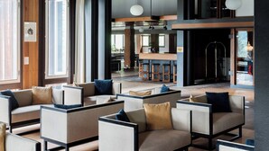 A spacious lounge area with multiple seating options, a bar area, and a high ceiling with exposed beams. - Hotel Boite (Borca di Cadore)