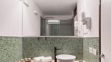 Ein Badezimmer mit grünen Fliesen an der Spritzwand, einem weißen Waschbecken und einem Handtuchhalter.