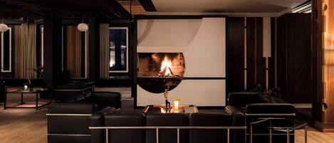Un salon moderne avec une cheminée, des canapés en cuir et un design minimaliste.