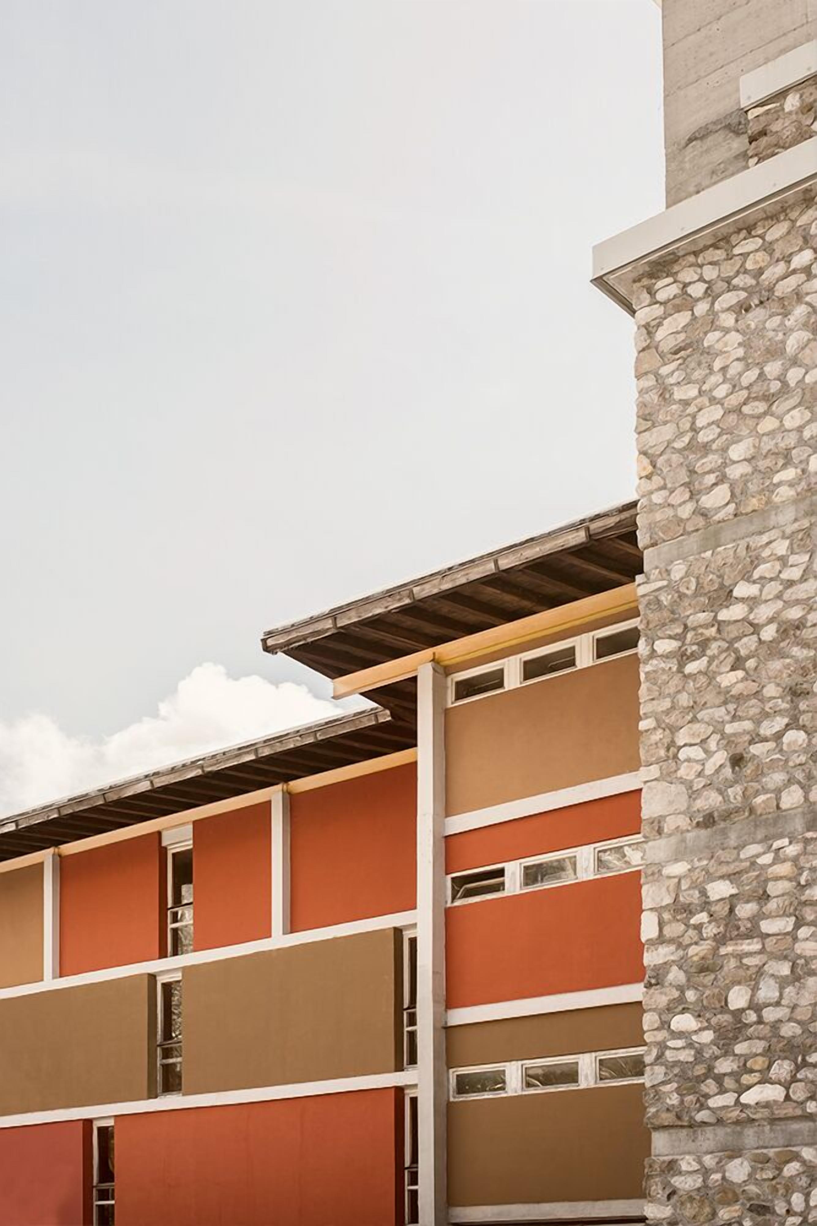 Un immeuble à plusieurs étages, doté d’une façade en pierre et d’un toit plat.